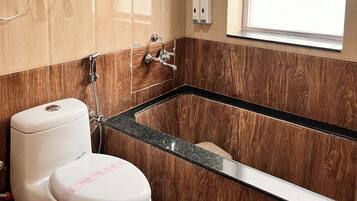 A bathroom with a toilet, a shower, and a bathtub.