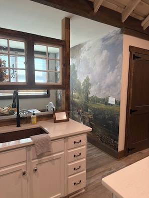 Una cocina con encimera de madera, un fregadero y un ventanal con vistas al paisaje.