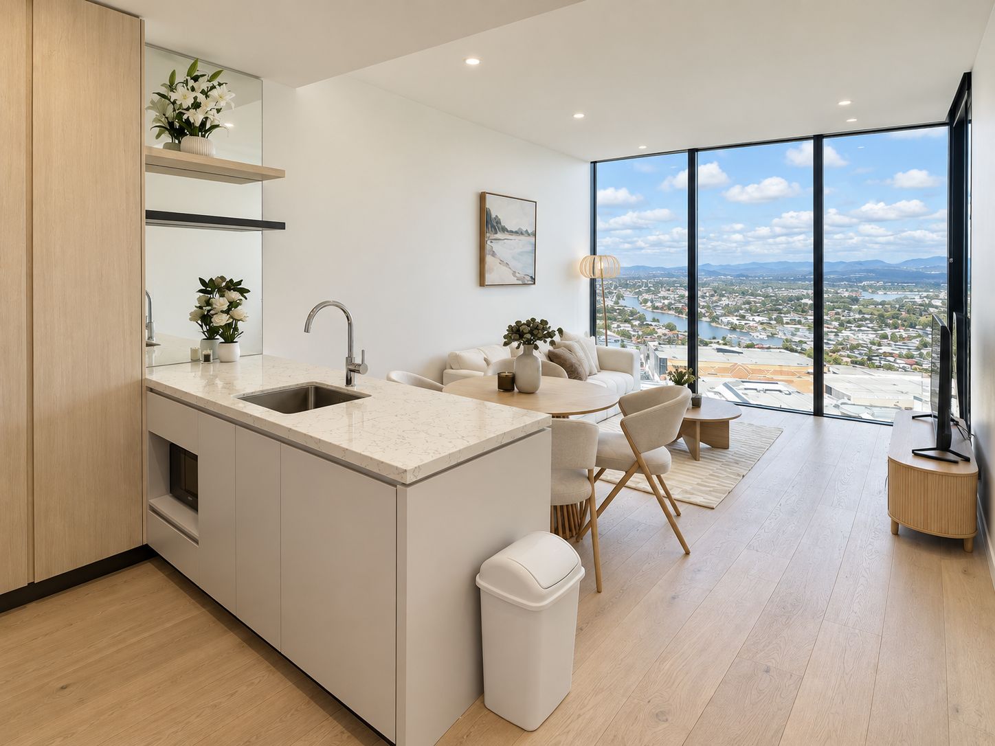 A modern kitchen with a built-in island, a dining area with a view, and a large window overlooking a cityscape.