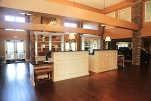 A spacious lobby with a reception desk, a fireplace, and a stone accent wall.