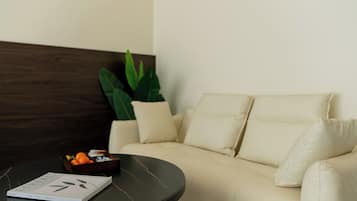 A modern living room with a beige sofa, a round coffee table, and a book.