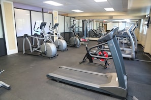 A gym with treadmills, elliptical machines, and weight equipment.