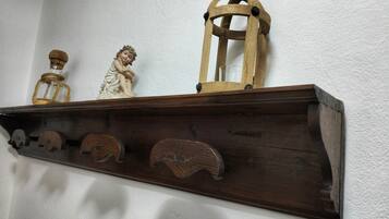 Ein Holzregal mit verschiedenen Gegenständen, darunter eine Figur, eine Laterne und eine Flasche.