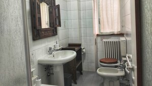 Et lille badeværelse med vask, toilet og bidet.