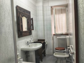 Une petite salle de bain comprenant un lavabo, des toilettes et un bidet.