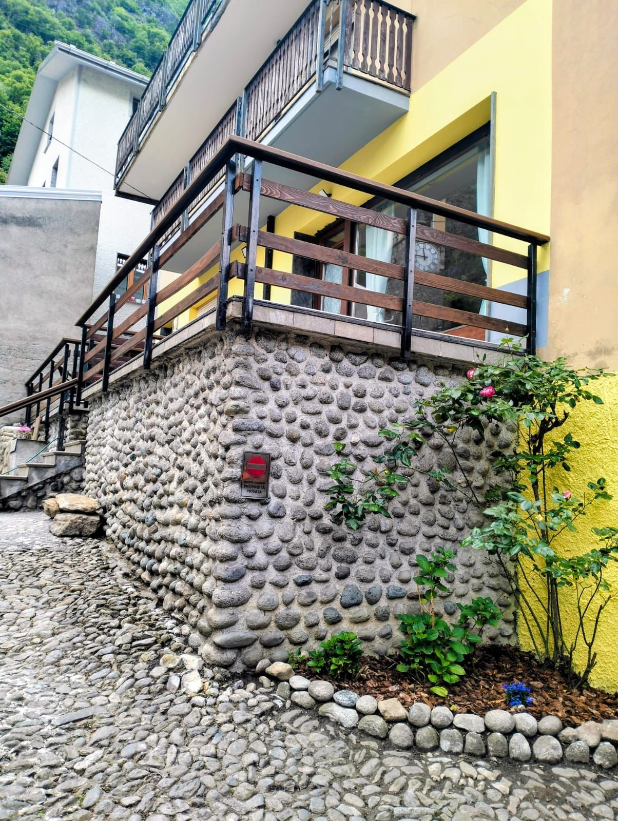 A building with a stone facade, a wooden balcony railing, and a sign indicating private property.