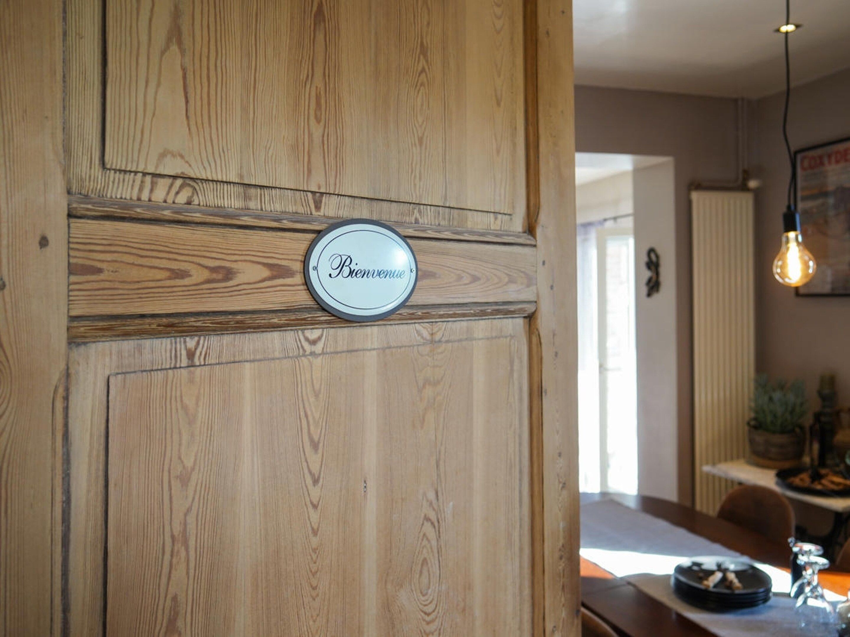 Een houten deur met een 'Bienvenue' bord.