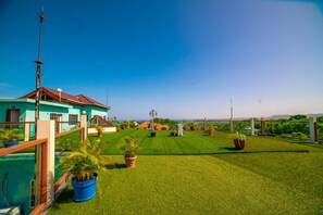 A residential property with a well-maintained lawn, a swimming pool, and a view of the ocean.