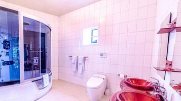A modern bathroom with a glass-enclosed shower, a white toilet, and red sinks.