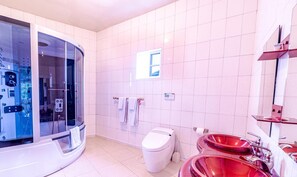 Moderni kylpyhuone, jossa on lasiseinällä varustettu suihku, valkoinen wc-istuin ja punaiset pesualtaat.