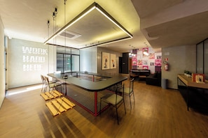 A modern interior with a central island table, bar stools, and a mix of seating options including a sofa and chairs. - Maracatins By Bhomy (São Paulo)