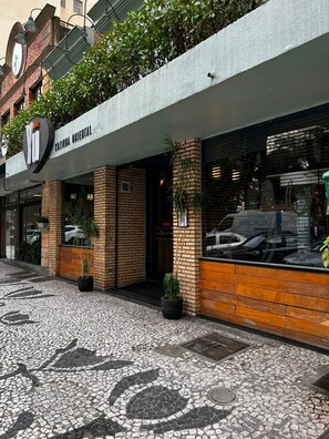 A building with a sign reading 'Cozinha Oriental' and a visible entrance. - Ap na rua das flores em Curitiba (Curitiba)