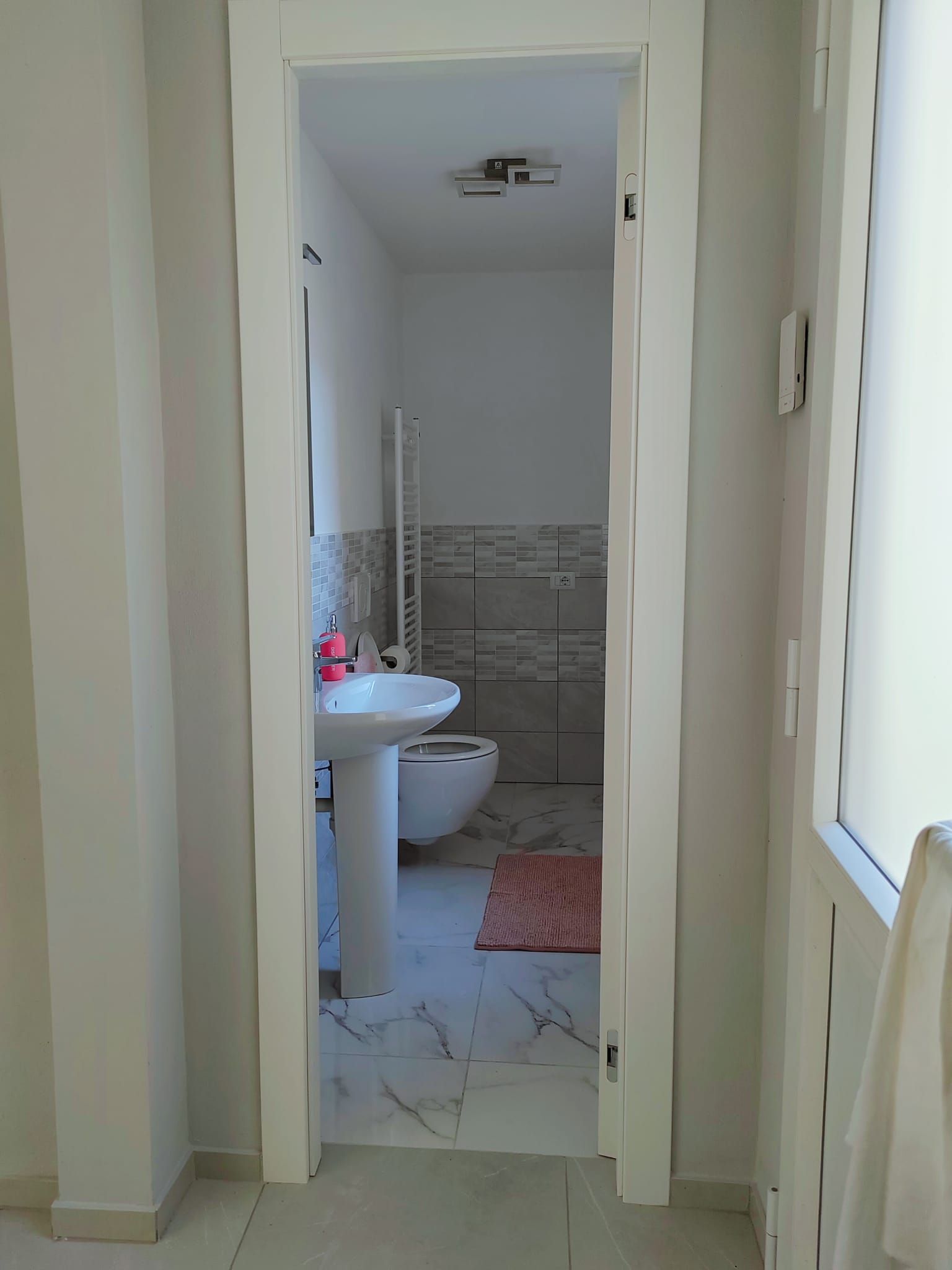 Ein Badezimmer mit Waschbecken, Toilette und Handtuchhalter.