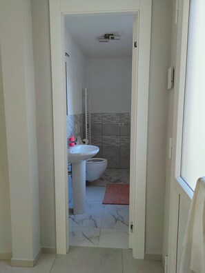 Ein Badezimmer mit Waschbecken, Toilette und Handtuchhalter.