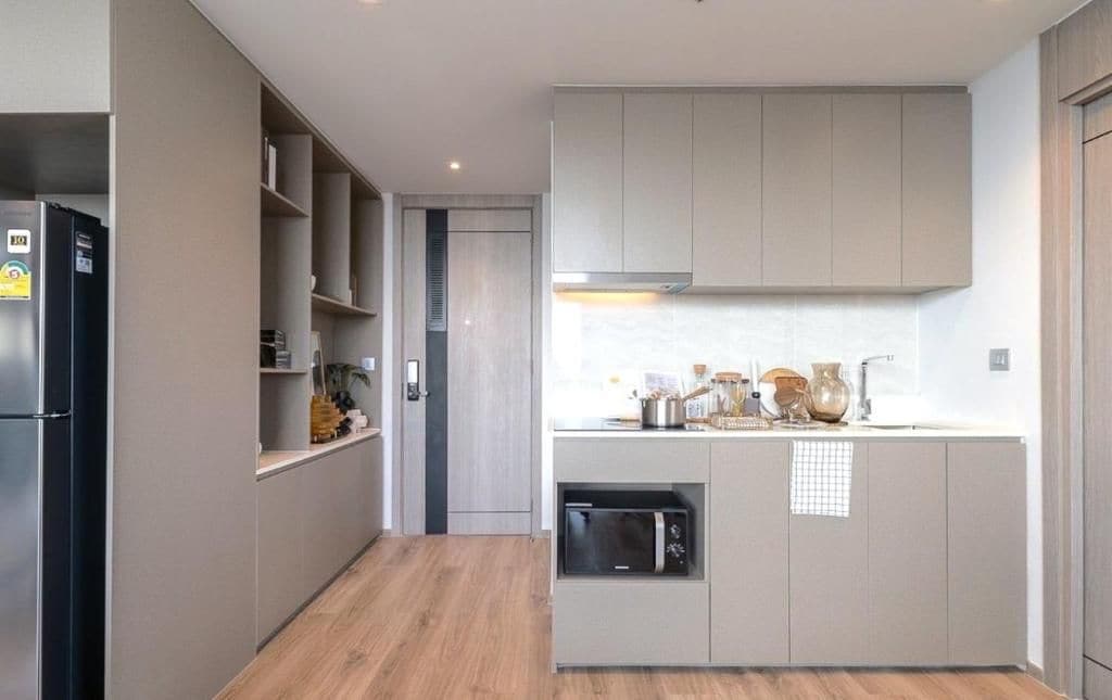 A modern kitchen with built-in appliances, a microwave, and a small oven.