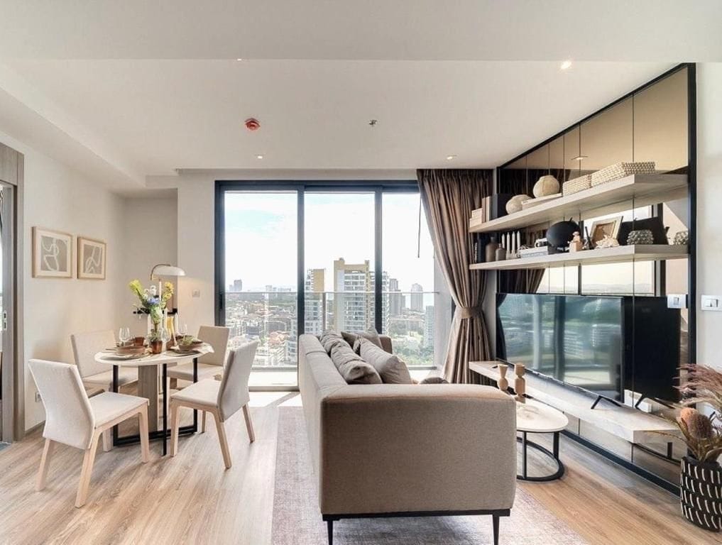 A modern living room with a sofa, dining table, and a TV.