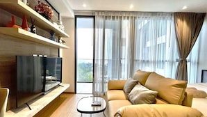 A modern living room with a sofa, a coffee table, and a flat-screen TV. - Andromeda Condominium Pattaya (Muang Pattaya)