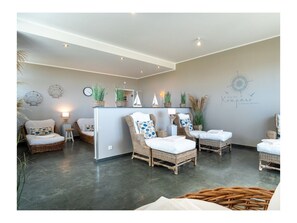Ein modernes Interieur mit Rattanmöbeln, einer zentralen Kücheninsel und dekorativen Wandelementen.