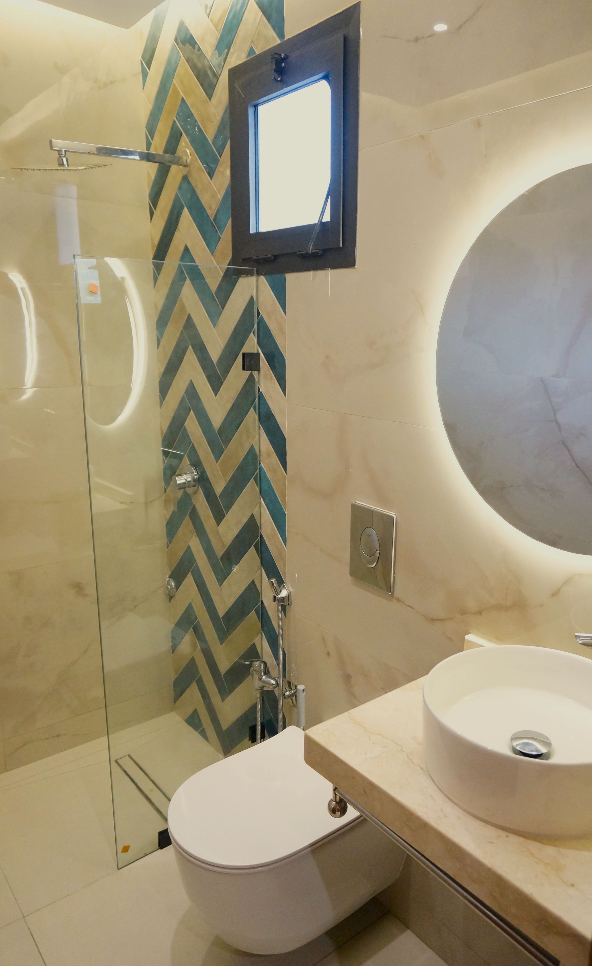 A modern bathroom with a glass shower enclosure, a white toilet, and a vanity with two sinks.