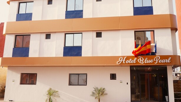Edifício de hotel com vários andares e placa indicando 'Hotel Blue Pearl' e 'Dakhla', indicando a localização.