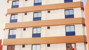 A multi-story hotel building with a sign reading 'Hotel Blue Pearl' and 'Dakhla' indicating its location.