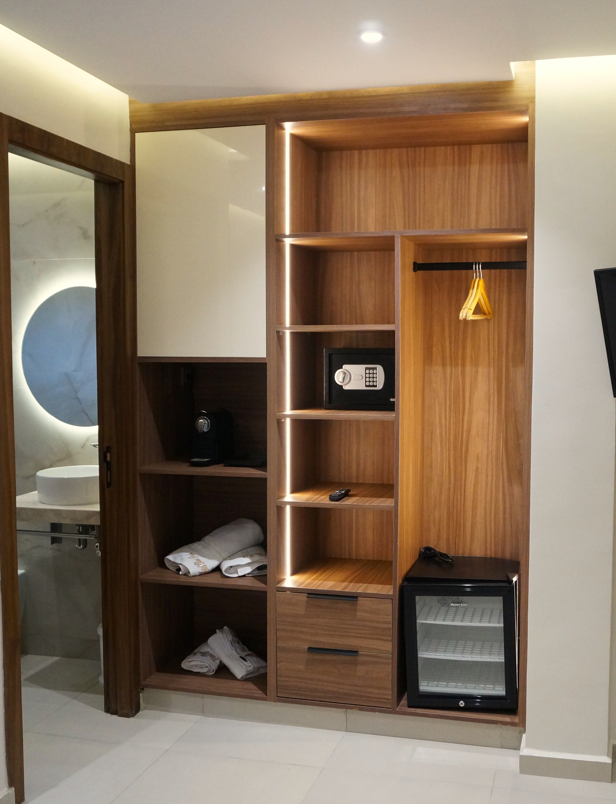 Un baño moderno con tocador, espejo y retrete.