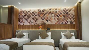 A hotel room with a modern design, featuring a large bed with two pillows and a headboard with a patterned design.