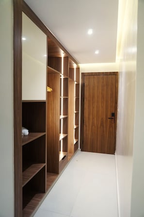 Un pasillo con un armario de madera, estantes y una puerta.