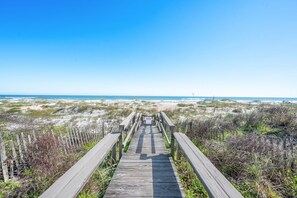 A wooden boardwalk leading to a beach with dunes and a clear sky. - 4BR Beach Cottage Pool Walk to Beach (St. Augustine)