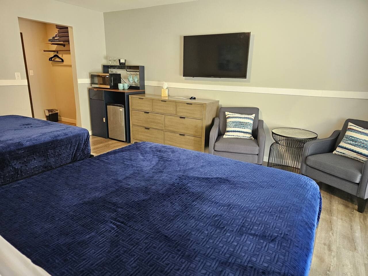 Une chambre d’hôtel avec deux lits, un bureau, une télévision et un coin salon.