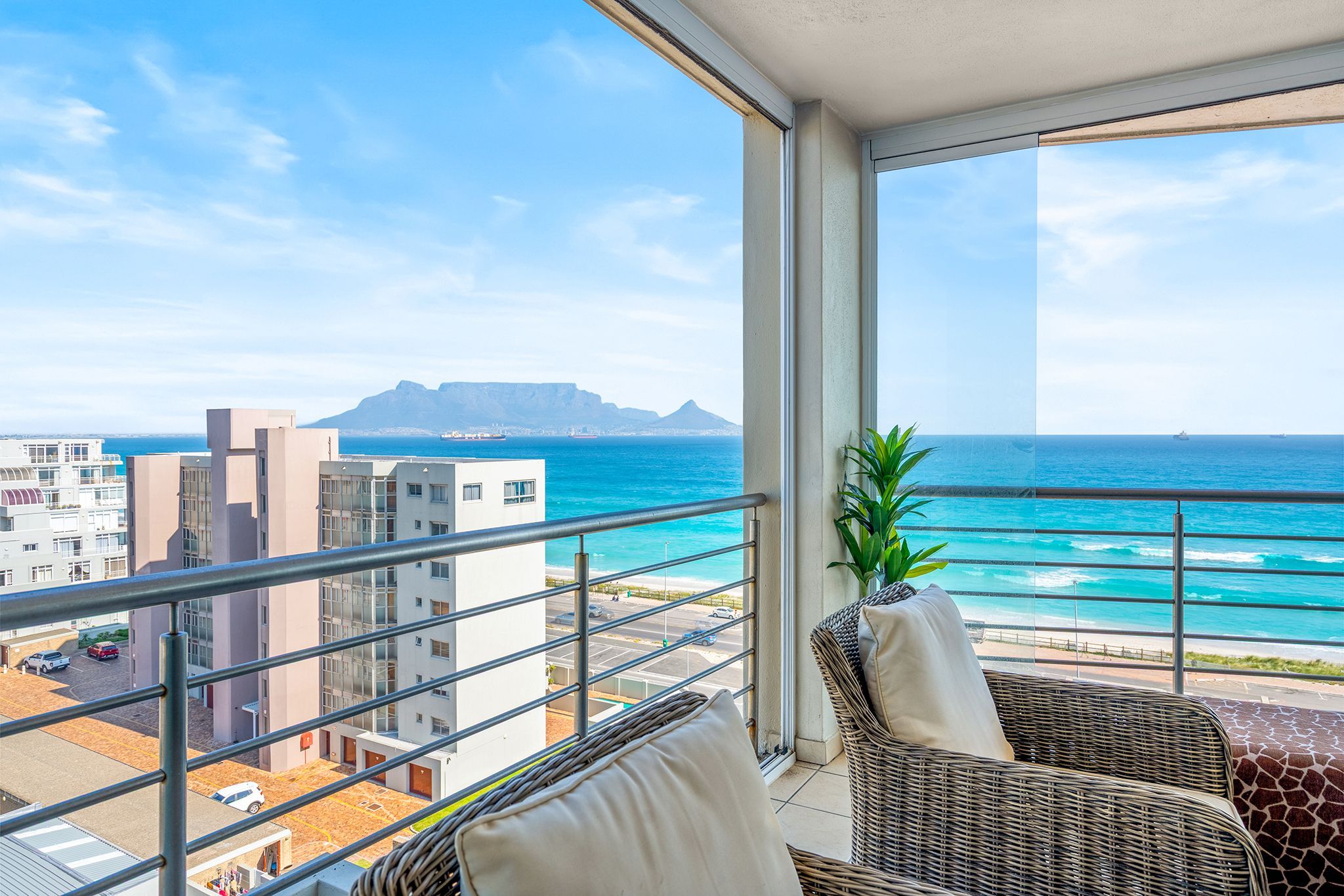 Un balcon avec vue sur l’océan et une montagne qui se profile à l’horizon.