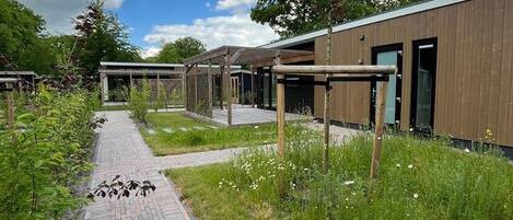 A modern building with a brick pathway and greenery.