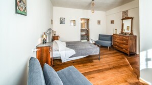A bedroom with a bed, a chair, a dresser, and a mirror. - defaultName (Monte Castello di Vibio)