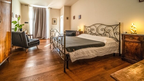 A room with a bed, a chair, a bedside table, and a wooden cabinet. - defaultName (Monte Castello di Vibio)