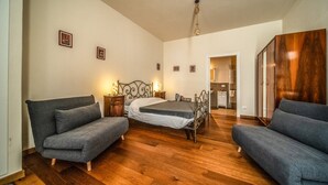 A bedroom with a bed, two sofas, a wardrobe, and a small bedside table. - defaultName (Monte Castello di Vibio)
