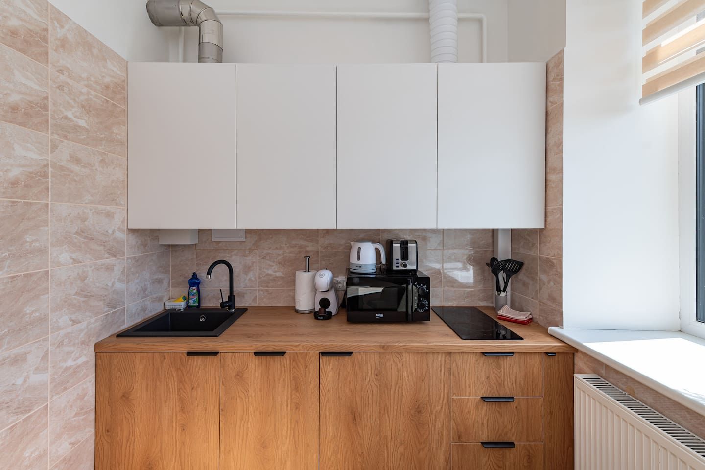 Eine moderne Küche mit doppelter Spüle, einer Kaffeemaschine, einem Toaster und einem Wasserkocher.