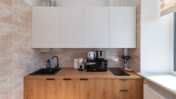 Eine moderne Küche mit doppelter Spüle, einer Kaffeemaschine, einem Toaster und einem Wasserkocher.