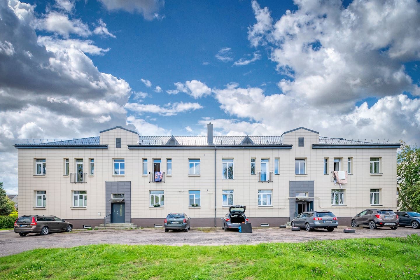 Un edificio residenziale a più piani con un'area di parcheggio antistante.