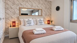 A hotel bedroom with a large bed, a mirror above it, and two bedside tables with candles. - Luxury Villa with a Heated Pool and Panoramic Ocean Views (Santiago del Teide)
