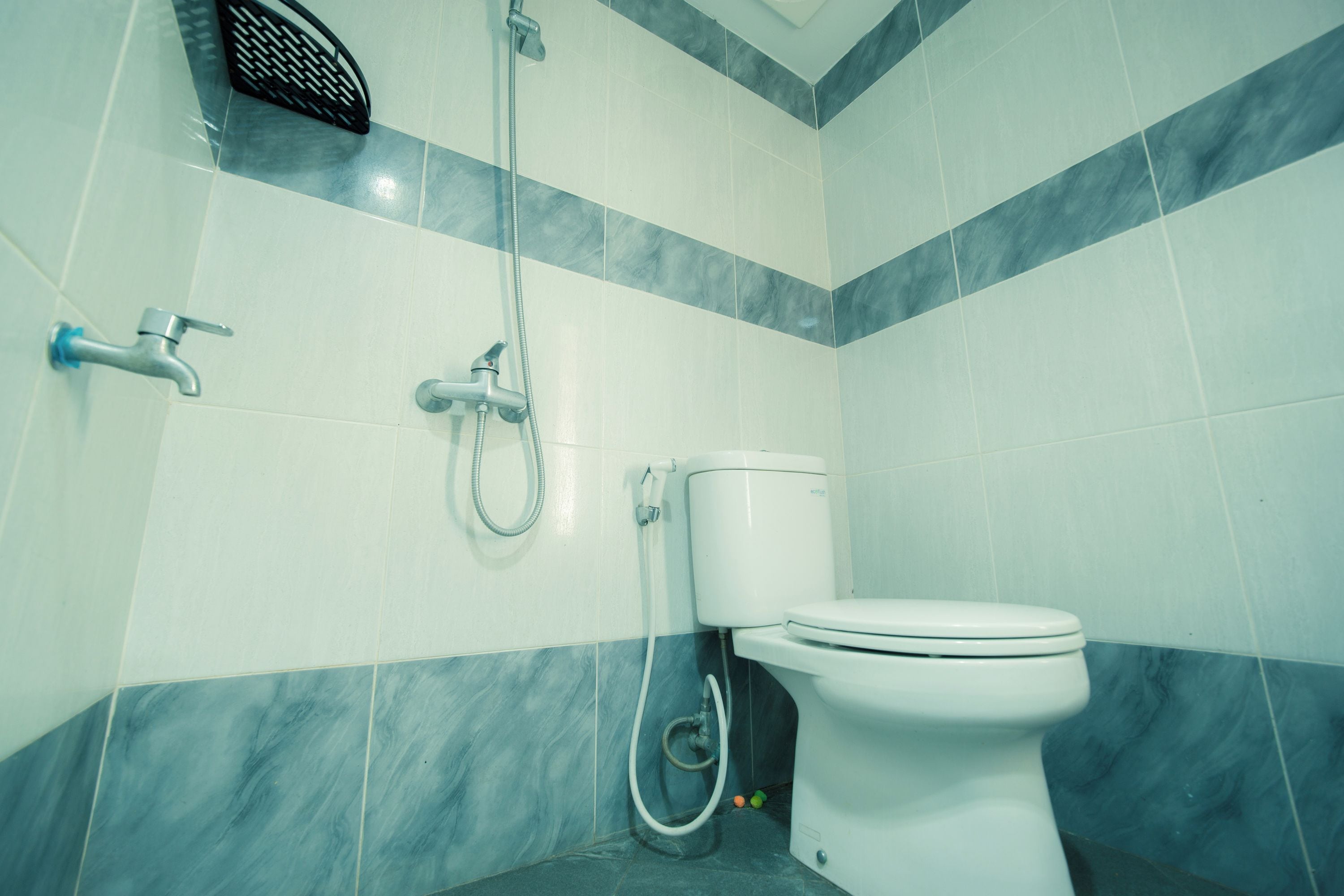 Un baño con inodoro, ducha y secador de manos.