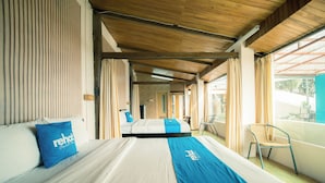 Een hotelkamer met een bed, een stoel en uitzicht op het omliggende landschap.