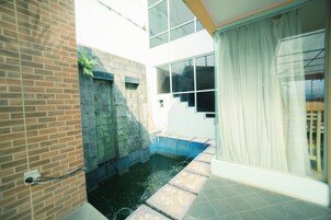A modern interior with a brick wall, a stone feature, and a small water feature.