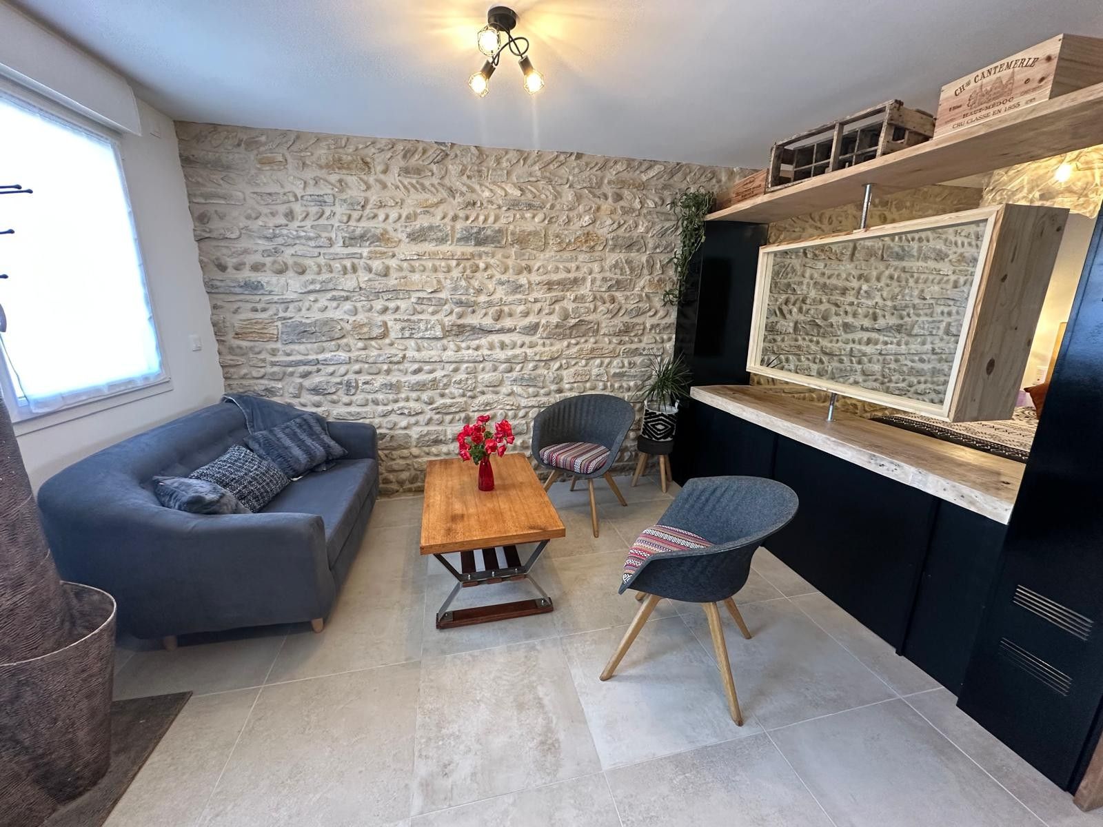 Een moderne woonkamer met een stenen muur, een bank, een salontafel en een stoel.