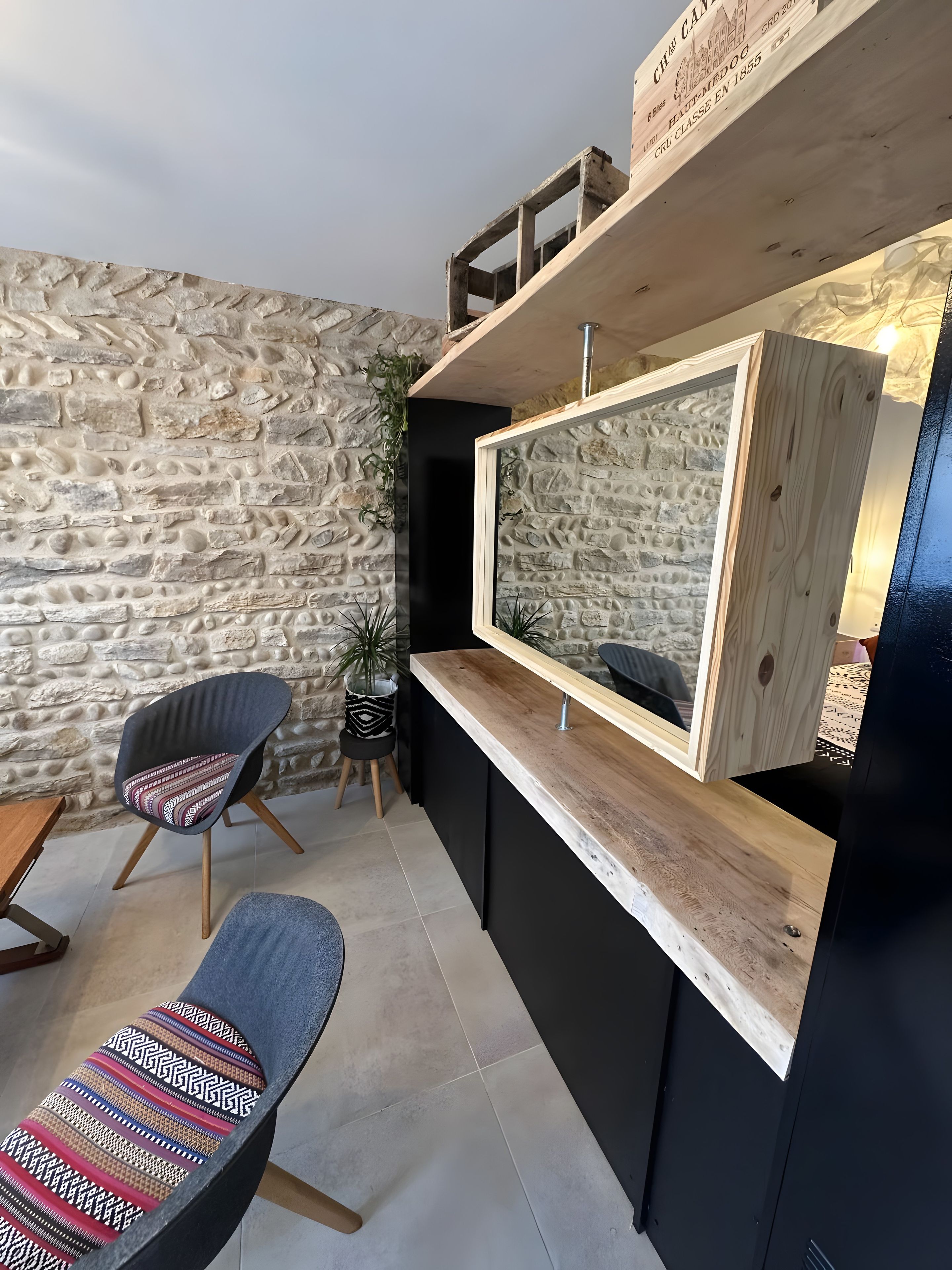 Un interior moderno con una pared de piedra, una encimera de madera y una silla con cojín estampado.