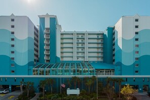 Hotel de disseny modern, amb façana de vidre central i distribució simètrica, amb diversos pisos i balcons.