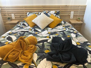 Un llit amb un estovat floral, dos coixins i dues tovalloles.