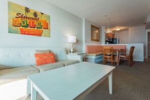 Een motelkamer met een bank, een eettafel en een keuken in de achtergrond.