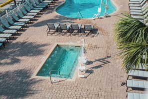 A pool area with lounge chairs and a small pool. - North Myrtle Beach | Marsh Escape | Pool & Beach Access | 2BR Villa (North Myrtle Beach)