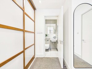 Ein modernes Badezimmer mit Toilette, Waschbecken und Spiegel.