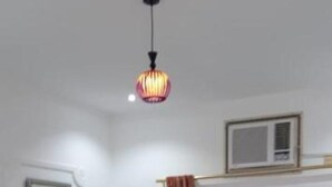 Une chambre d’hôtel comprenant un lit, un bureau, une chaise, une armoire et un luminaire au plafond.